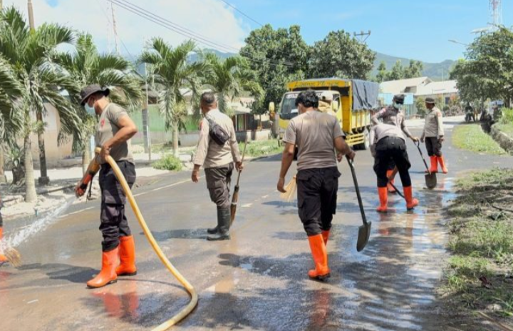 Polres Flotim Bersama BKO Polda NTT Bersihkan Abu Vulkanik di Jalan Trans Larantuka Maumere
